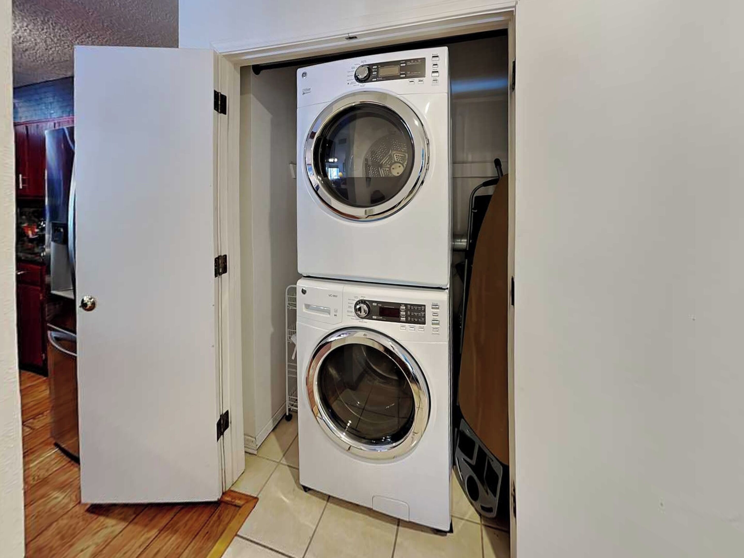 A compact laundry room with two stacked front-loading washing machines.