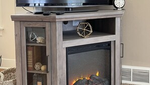 A television on a wooden stand with a fireplace below. - 3 Bed, 2 Bath Cozy Home Across from Zoo in the heart of Baraboo. (Baraboo)