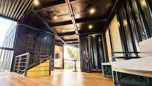 A spacious room with a staircase, large windows, and a fan. - Tuan Chau Ruby Villa (Tuan Chau)