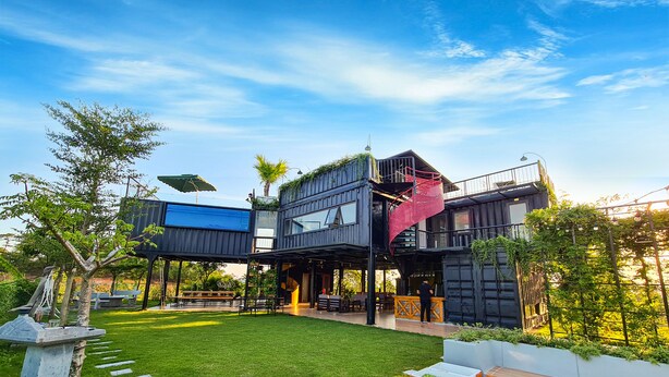 A modern building with a covered outdoor area, including a staircase and seating. - Tuan Chau Ruby Villa (Tuan Chau)