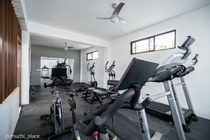 Ein Fitnessstudio mit Laufbändern, Fahrrädern und Kraftgeräten.