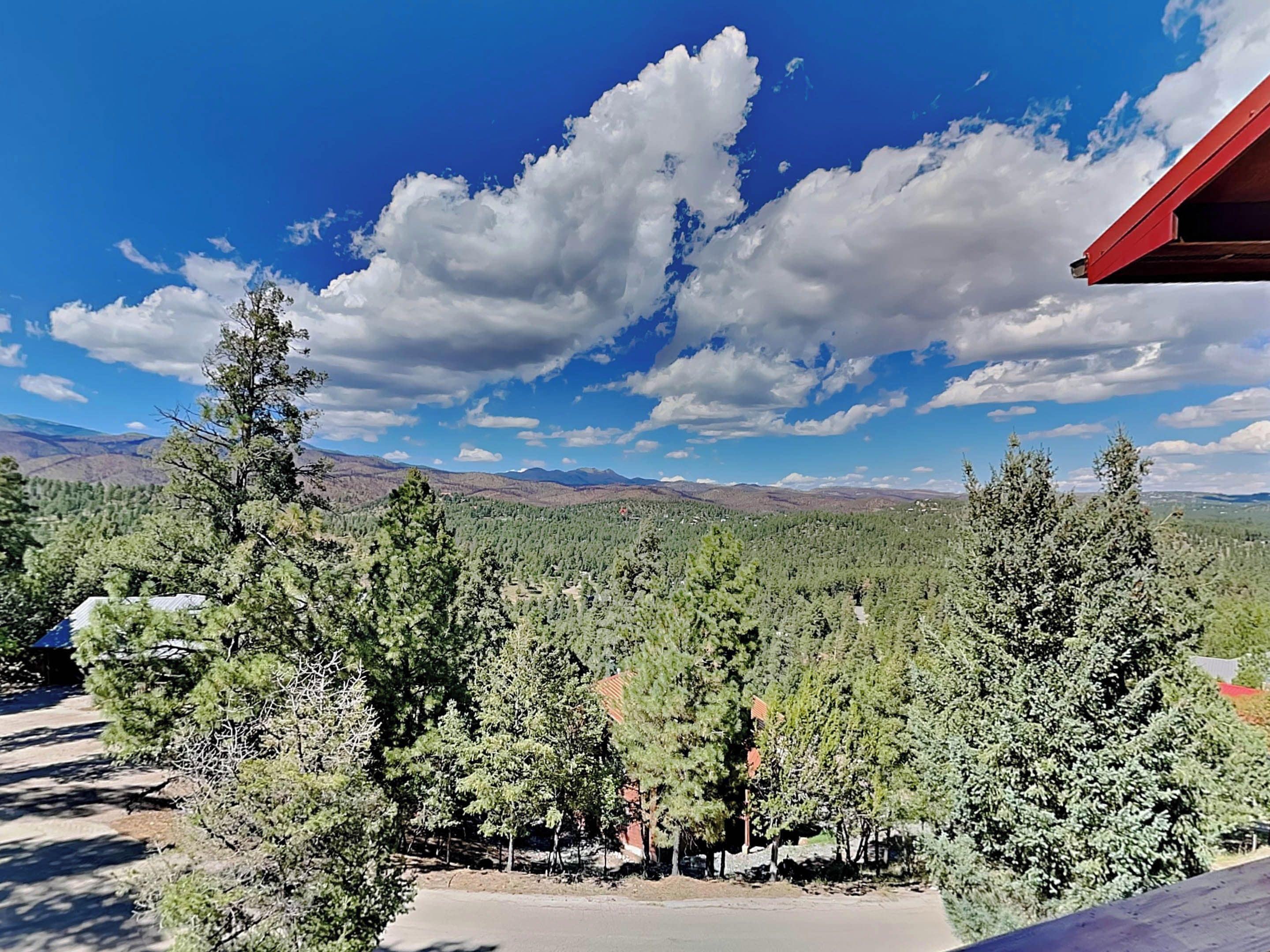 A mountainous landscape with dense forests and a clear blue sky.