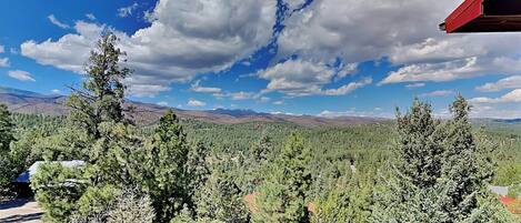 A mountainous landscape with dense forests and a clear blue sky.