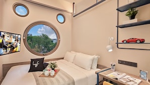 Une chambre d’hôtel moderne avec un grand lit, un petit bureau et une fenêtre donnant sur la ville.