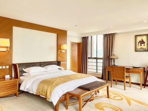 A hotel room with a large bed, a desk, a chair, and a view of the outdoors. - Purple Light Hotel (Zhaotong)
