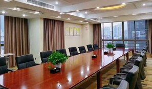 A conference room with a long table, chairs, and a potted plant. - Purple Light Hotel (Zhaotong)