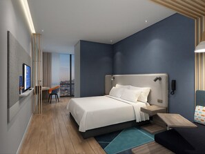 Une chambre d’hôtel moderne, dotée d’un grand lit, d’un bureau, d’une chaise et offrant une vue sur la ville.