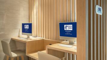 Um hall de hotel moderno com duas estações de computador, cada uma exibindo o logotipo Holiday Inn Express, e uma placa indicando a localização como Centro da Cidade de Yangjiang.