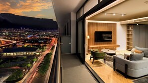 A modern apartment with a balcony overlooking a cityscape at dusk. - The Rockefeller Hotel by Newmark (Cape Town)
