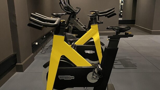 A gym with stationary bikes, a treadmill, and a rowing machine. - The Rockefeller Hotel by Newmark (Cape Town)
