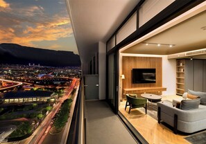 A modern apartment with a balcony overlooking a cityscape at dusk. - The Rockefeller Hotel by Newmark (Cape Town)