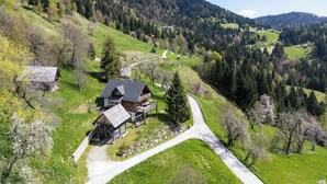A rural landscape with a winding road, wooden houses, and a mountain backdrop. - Pure nature with amazing view (Podjelje)