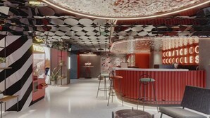 Un interior moderno con un mostrador de recepción curvo, zona de estar y techo con diseño.