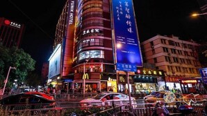 Un hotel con un letrero llamativo, un gran anuncio iluminado y un restaurante McDonald's.