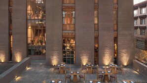 A building with large windows and a courtyard with tables and chairs. - Chospa Hotel (Leh)