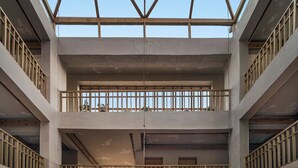 A multi-level atrium with a central seating area, large hanging lamps, and a staircase. - Chospa Hotel (Leh)