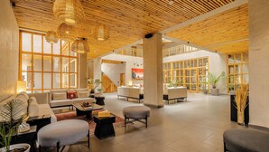 A spacious lobby with a high ceiling, large windows, and a modern design. - Chospa Hotel (Leh)