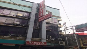 Een meerlaags gebouw met borden waarop 'VISTA APARTMENTS & RESTAURANT' en 'CITYSTA SAYSINGS BANK' staan.