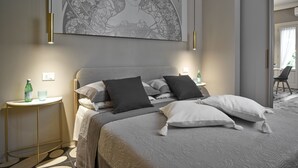 Un dormitori modern amb un llit gran, una taula de nit i una obra d'art penjada a la paret.