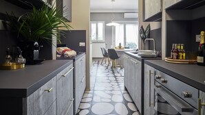 Una cuina moderna amb armaris grisos, una illa central i una zona de dinar amb cadires.