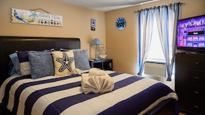 A bed with a striped bedspread, a starfish pillow, and a towel on the bed. - Pleasant Days Manatee Room (Homosassa)