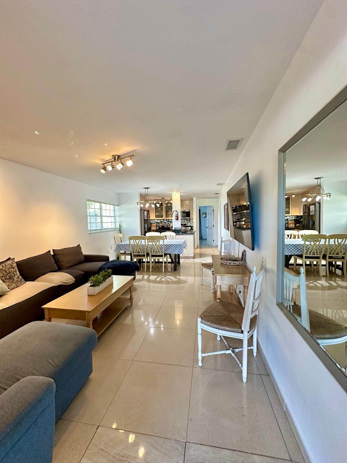 A modern living room with a sofa, coffee table, and dining area.