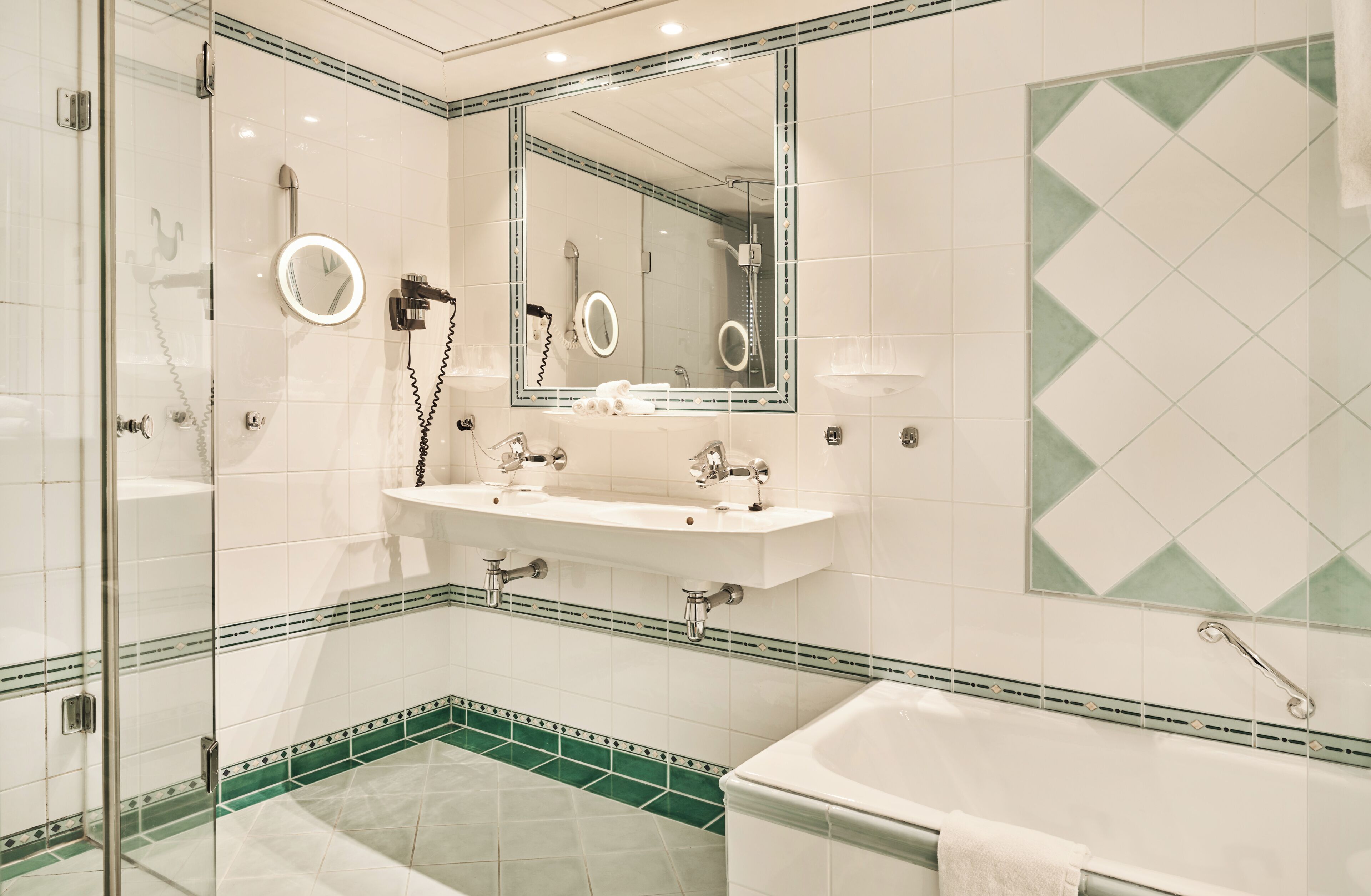Une salle de bain avec une douche à parois de verre, un lavabo avec un miroir et une baignoire.