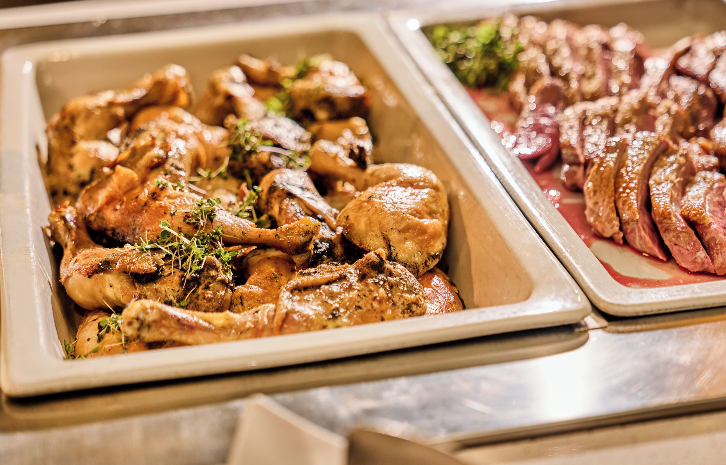 Un buffet con pollo arrosto e fette di manzo.