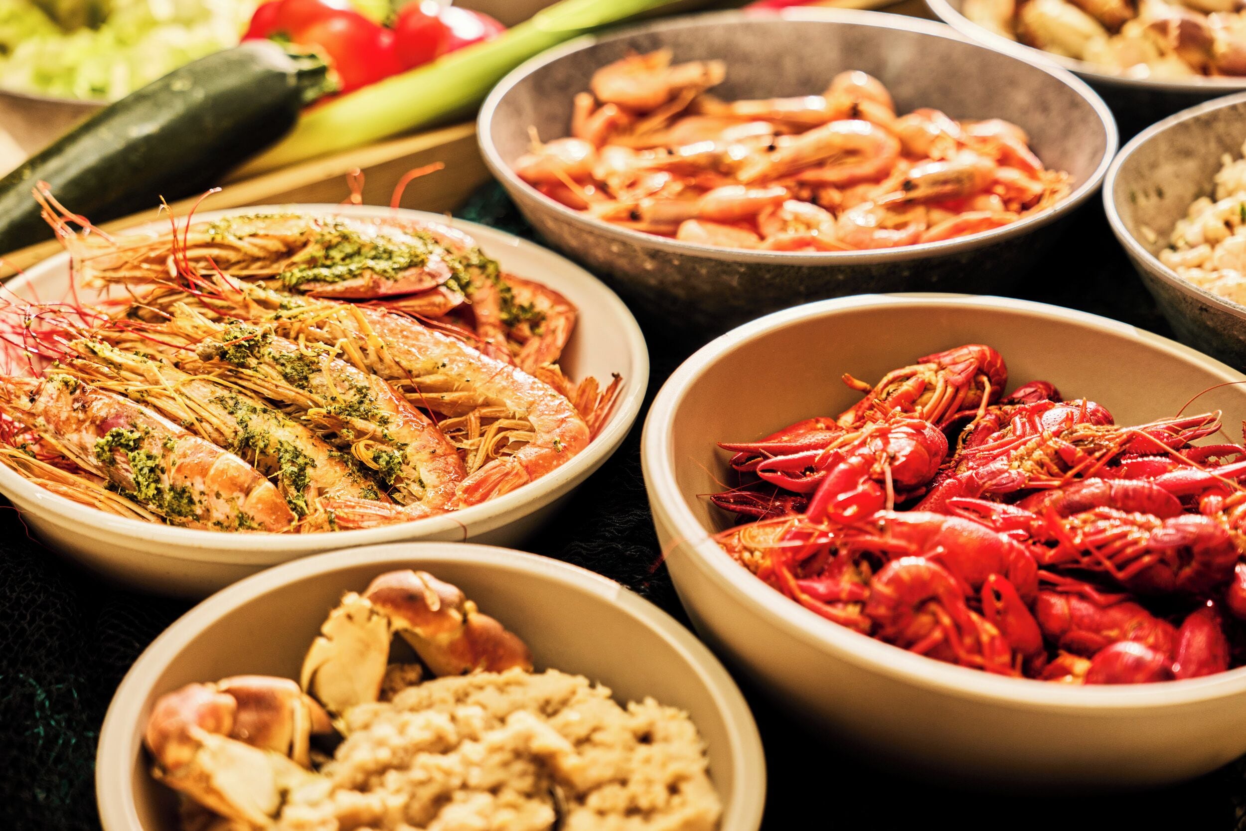 Variedad de platos de mariscos, incluyendo camarones y langostinos, en cuencos.
