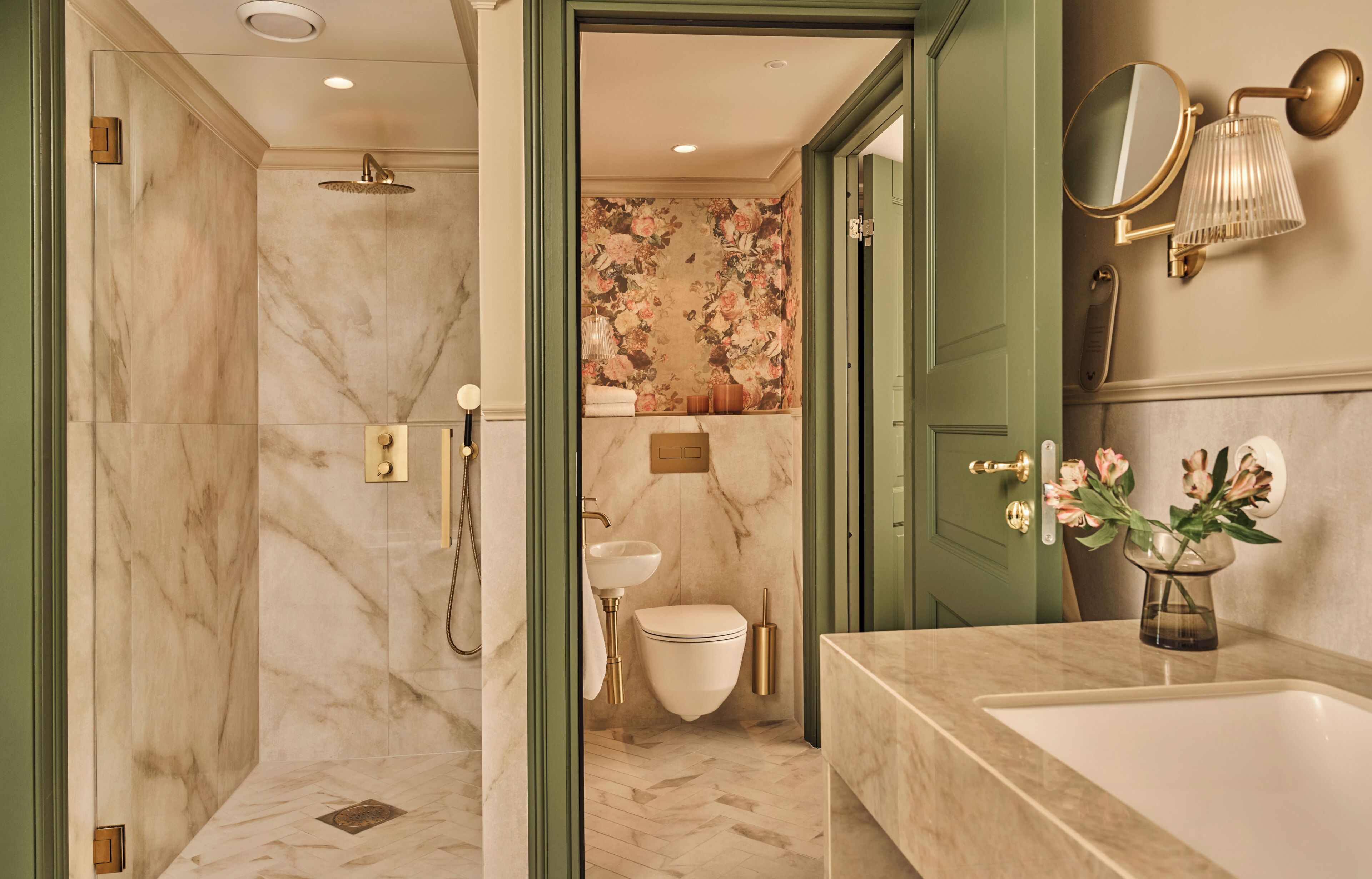 A bathroom with a shower, toilet, sink, and a mirror.