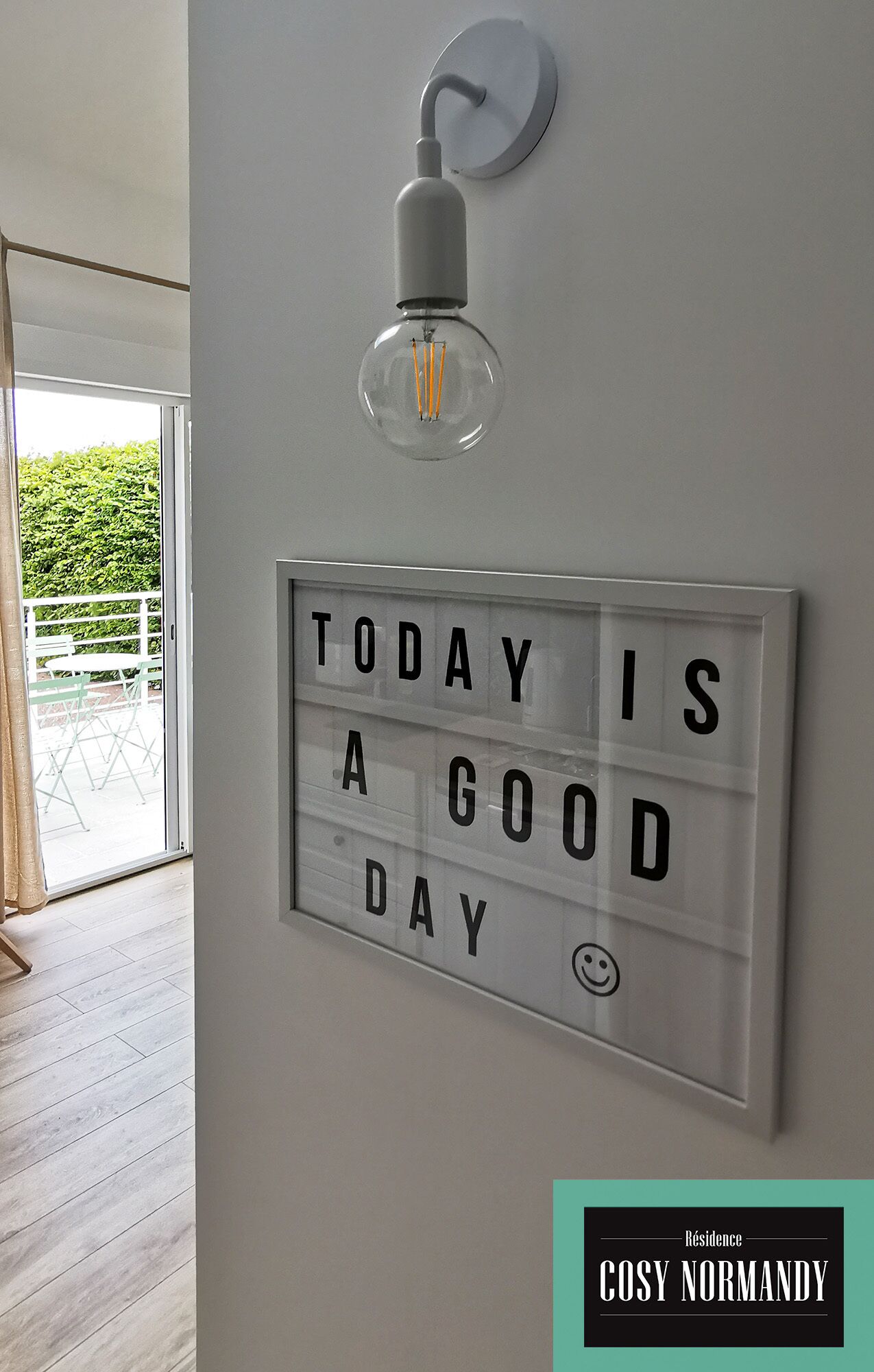 A room with a light fixture and a motivational sign on the wall.