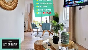 Sala de estar moderna con cartel de recepción, amplio estacionamiento, WiFi rápido, terraza con patio y Netflix gratis.