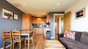 A compact living space with a dining area, kitchenette, and a sofa. - Modern, Spacious City Apartment, Lift, Balcony, Free Wi-fi & Parking, Fab views, (Edinburgh)