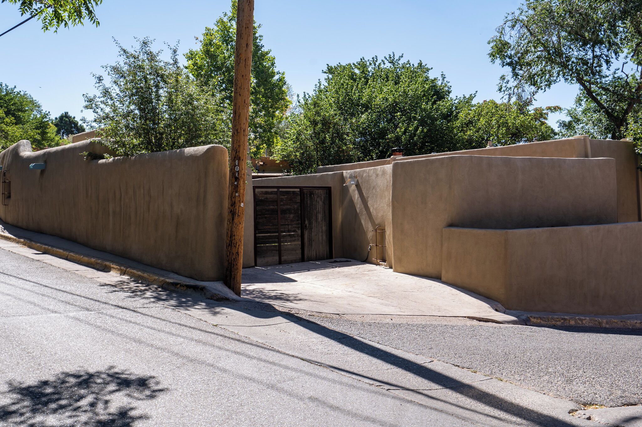 A building with a concrete facade, a wooden door, and a small overhang.