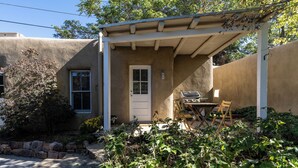 A house with a covered patio, a door, and a window. - Fiddler's Retreat by Kokopelli Property Management (Santa Fe)