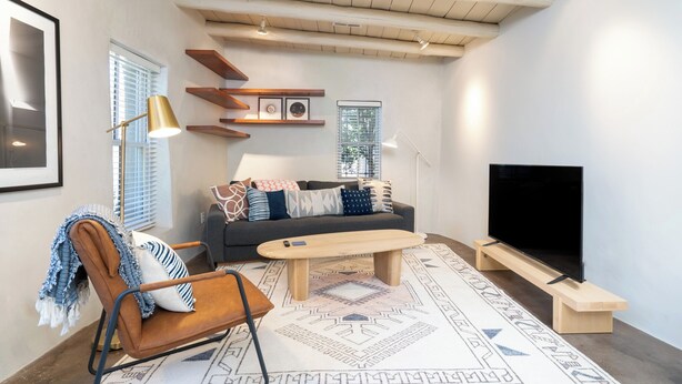 A modern living room with a sofa, coffee table, and TV stand. - Fiddler's Retreat by Kokopelli Property Management (Santa Fe)