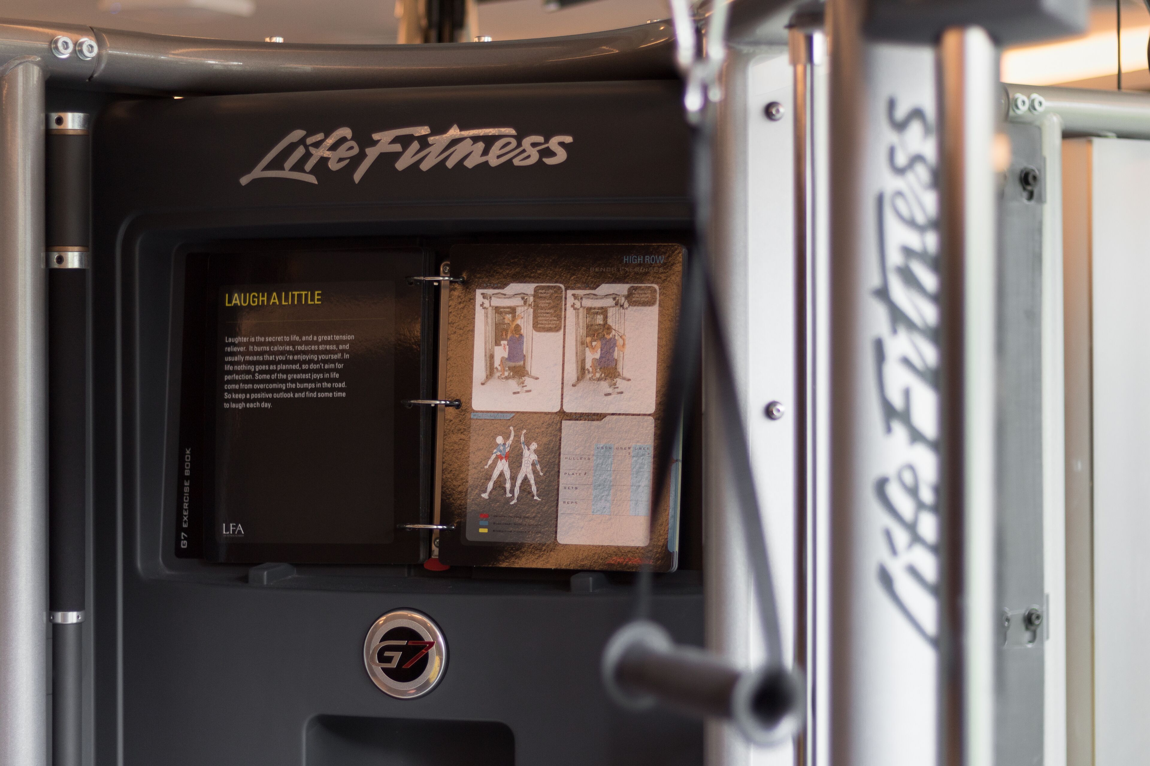 A gym equipment with a Life Fitness logo and an exercise book attached.