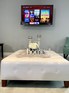 Een 70-inch flatscreentelevisie met kabelzenders en televisie