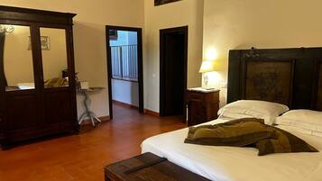 A bedroom with a bed, bedside table, lamp, and a wooden wardrobe.