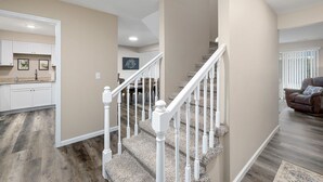 A spacious living area with a staircase, a dining area, and a kitchen. - WALK IN, Pointe Royale, Arcade, Indoor Pool (Branson)