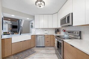 Enjoy cooking in this well-lit kitchen with an oven, sleek cabinetry, and a stainless steel dishwasher.