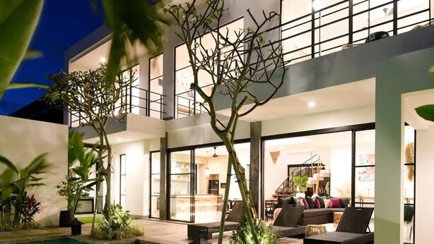 A modern two-story house with a swimming pool, outdoor seating, and a well-lit interior. - Villa Soho (Canggu)
