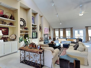 A spacious living room with a pool table, comfortable seating, and a large window providing natural light. - A Trip to Heaven by Ruidoso Vacation Rentals (Ruidoso)
