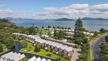 A coastal residential area with a row of houses, a road, and a body of water.