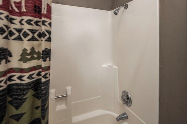 Ducha con puerta blanca y cabezal.