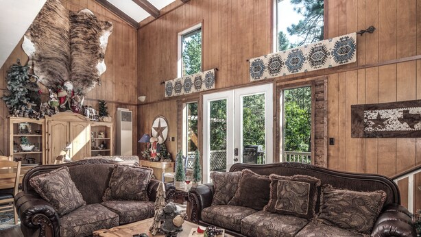 A cozy living room with two brown patterned sofas, a wooden coffee table, and a large fur rug. - Tis Holiday Haus by Ruidoso Vacation Rentals (Ruidoso)