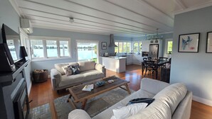 A spacious living area with a sofa, coffee table, and a kitchen in the background.