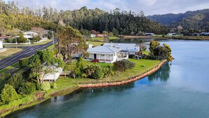 A lakeside property with a house, a dock, and a road.