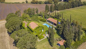 An aerial view of a property with a swimming pool, a house surrounded by trees, and fields in the background. - Casale Teresa (Tarquinia)