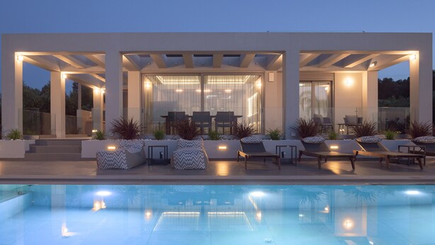 Zona de piscina exterior moderna amb gandules i un porxo de vidre.